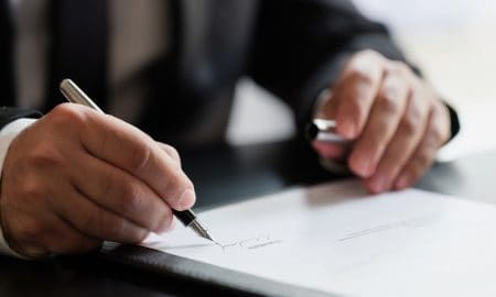 Signing a document featured